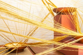 Goldfäden sammeln und bündeln sich in vergoldeten Schalen 
